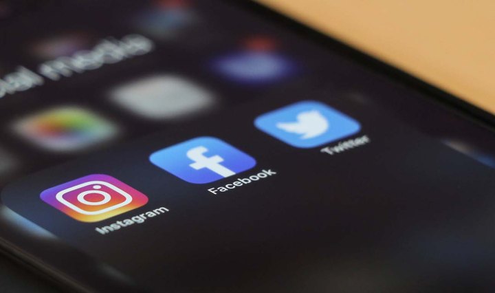 A mobile phone with Instagram, Facebook and Twitter apps showing on the homepage
