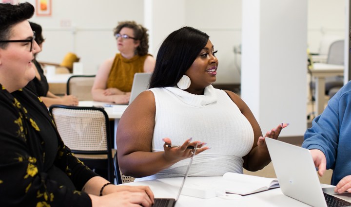 Two white women and a Black woman speak and smile