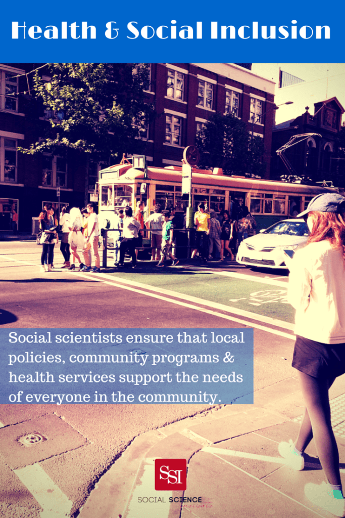 A woman waits by the side of the road waiting to cross. In the background people wait for a tram