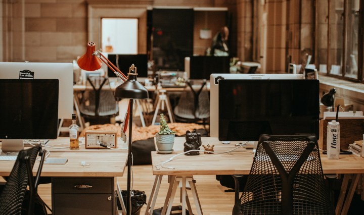 An empty office with desks and laptops