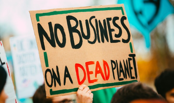 Protesters hold a sign that reads: no business on a dead planet