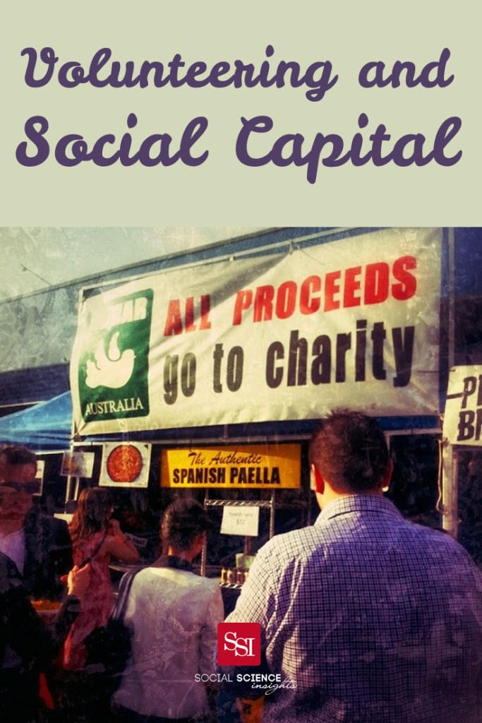 People stand in front of a sign that reads: All proceeds go to charity