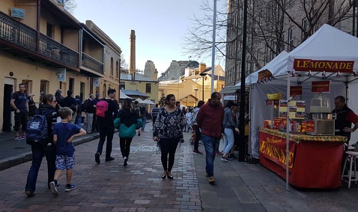 People walk through a market in Sydney