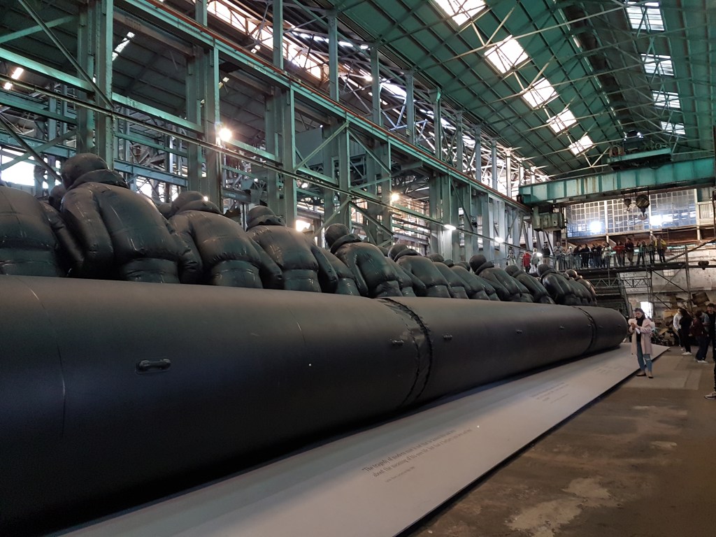 Side view of the raft and figures bent inwards, made of black rubber 