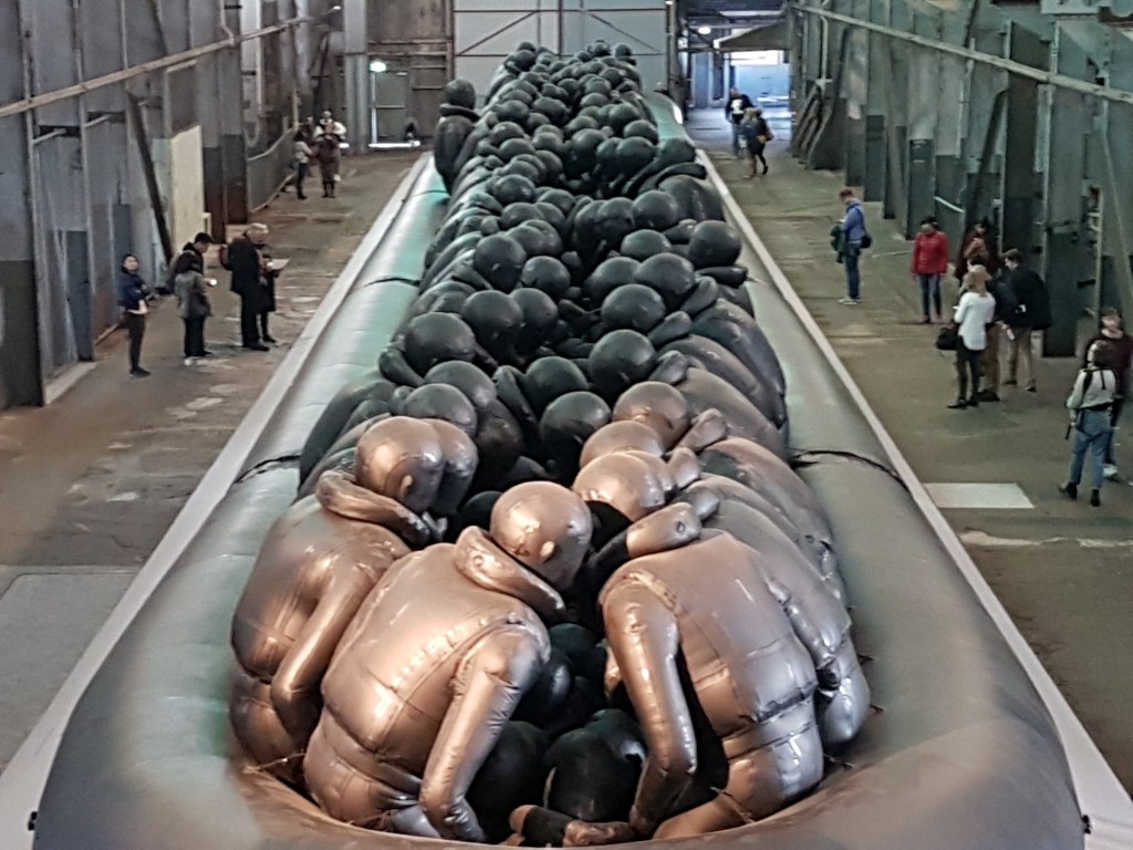 Close-up of black rubber figures with their heads bowed
