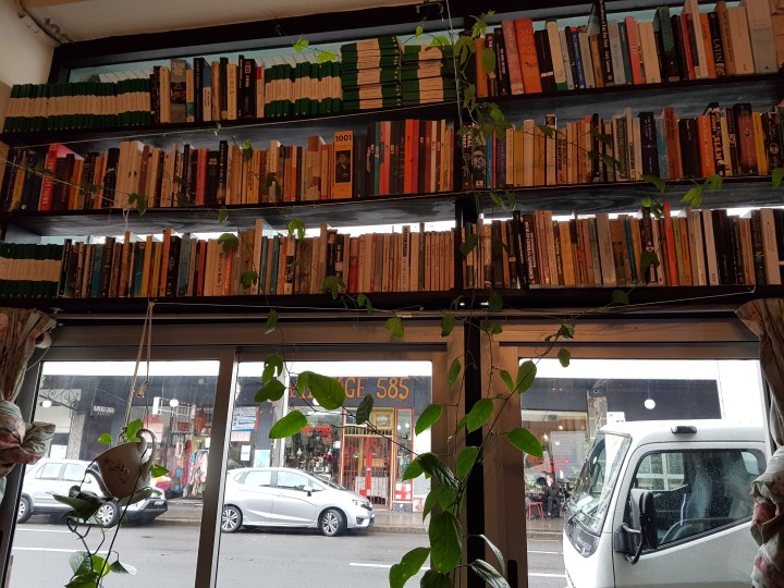 Books on floating shelves above a window