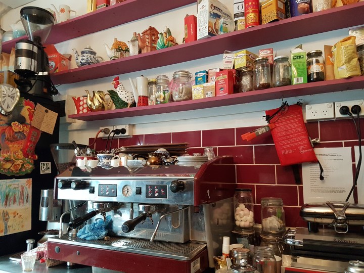 A coffee machine with spices along a shelf
