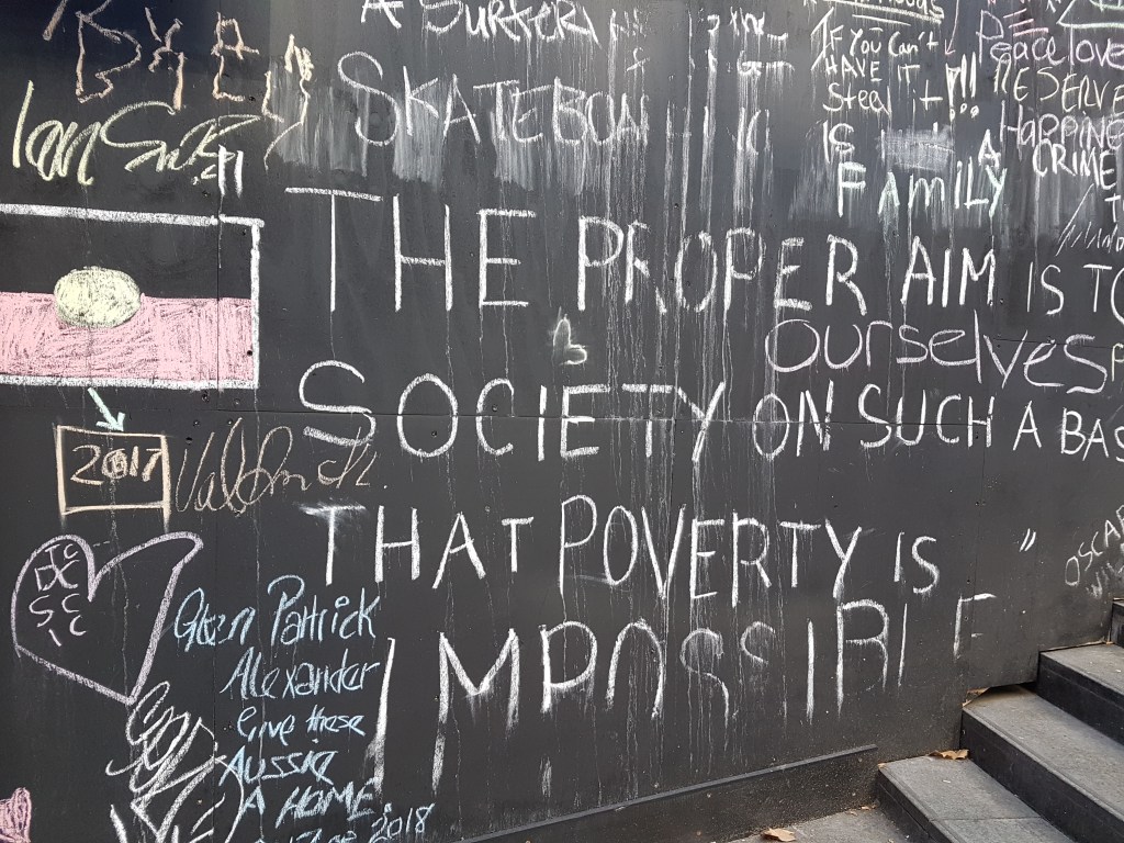 Chalk writing says, in part: The proper aim is to [...] outselves [...]That poverty is impossible