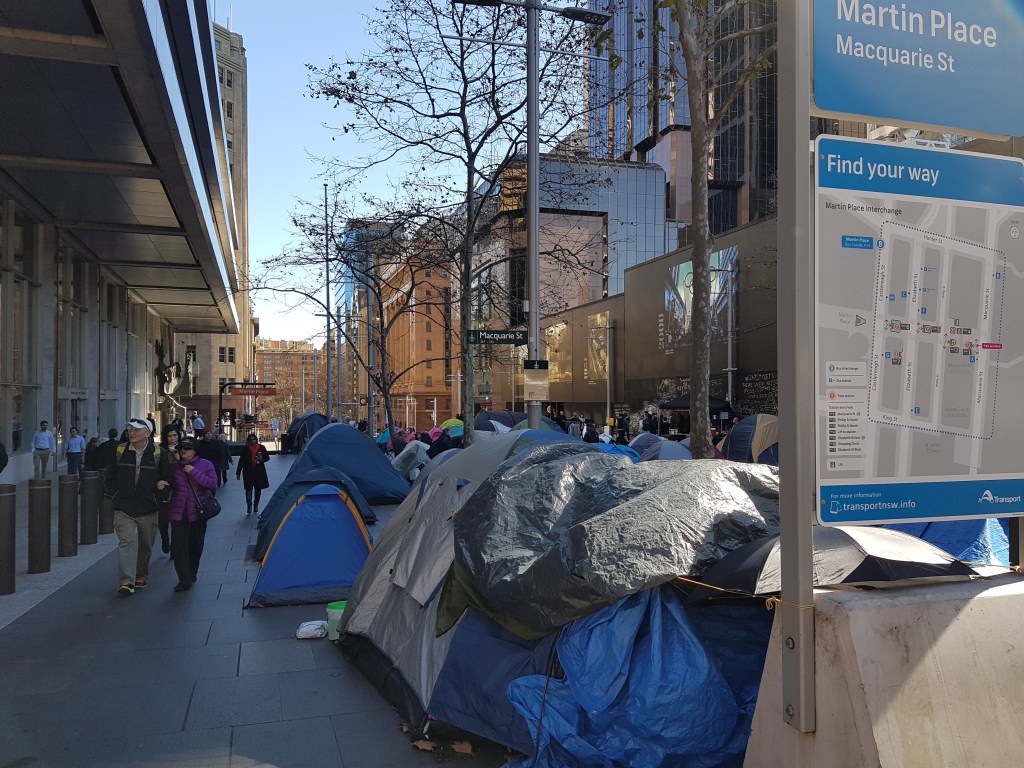 People walk alongside tents