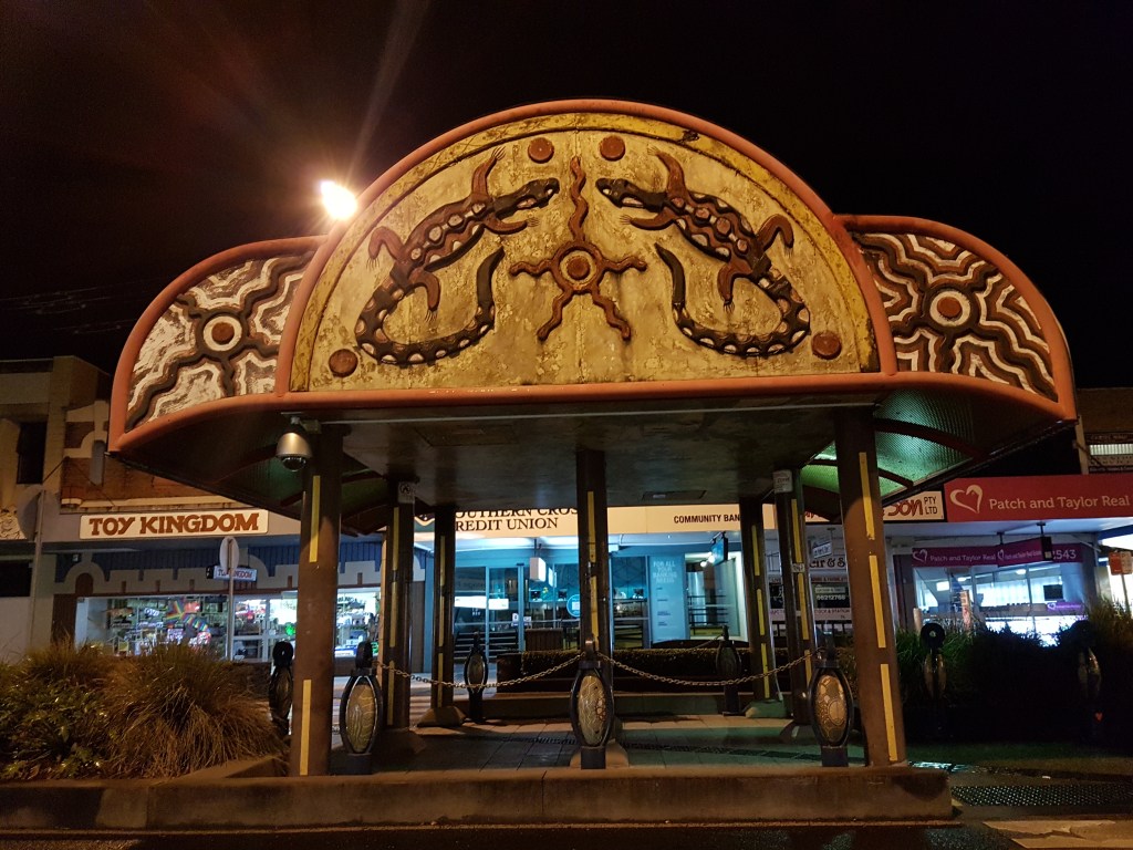 Gazebo in the centre of Lizmore at night shows Aboriginal artwork of two goannas