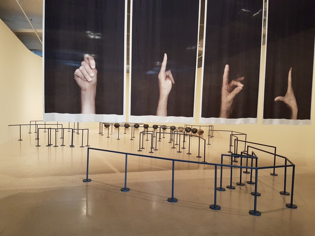 Installation of a series of rails, with large images of hands making gestures