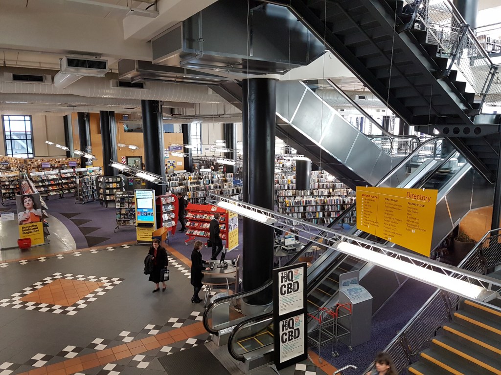 Inside of the Wellington Central Library, where many shelves of books stand in the background