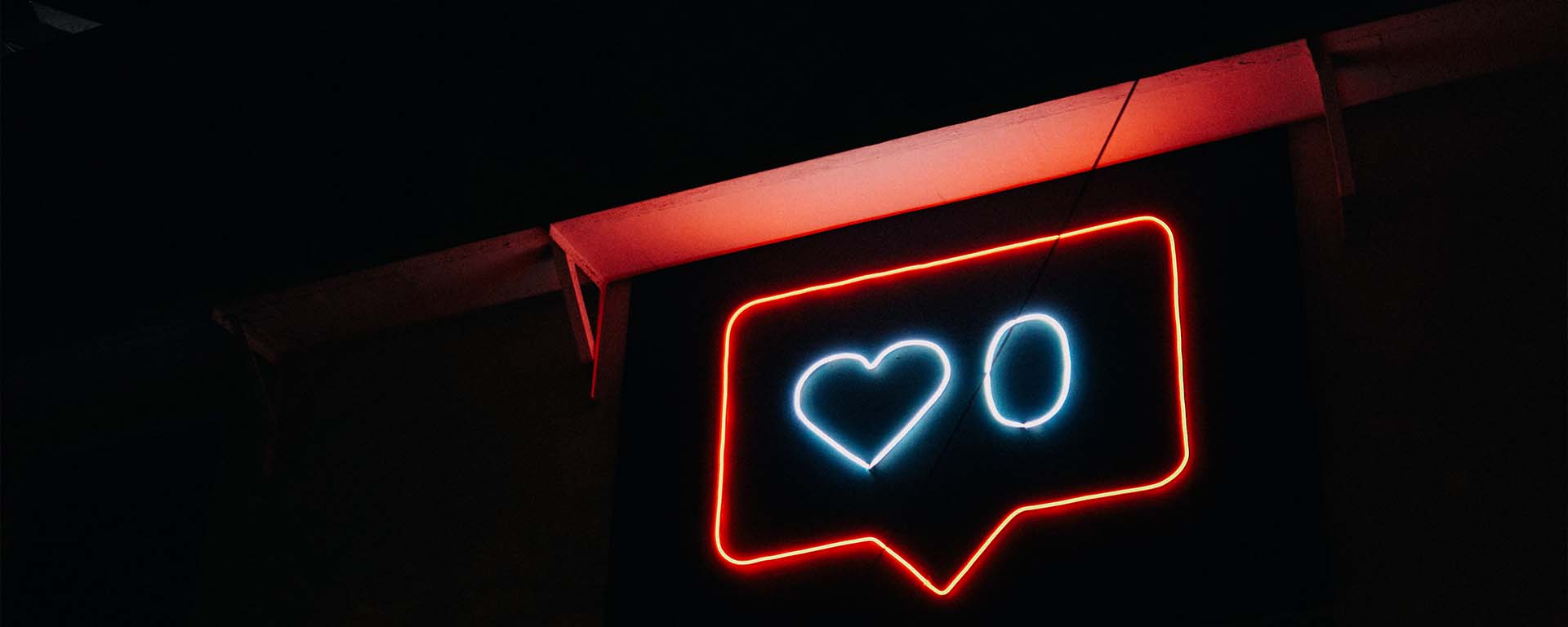 Neon sign showing a speech bubble sign with a love heart and the number zero