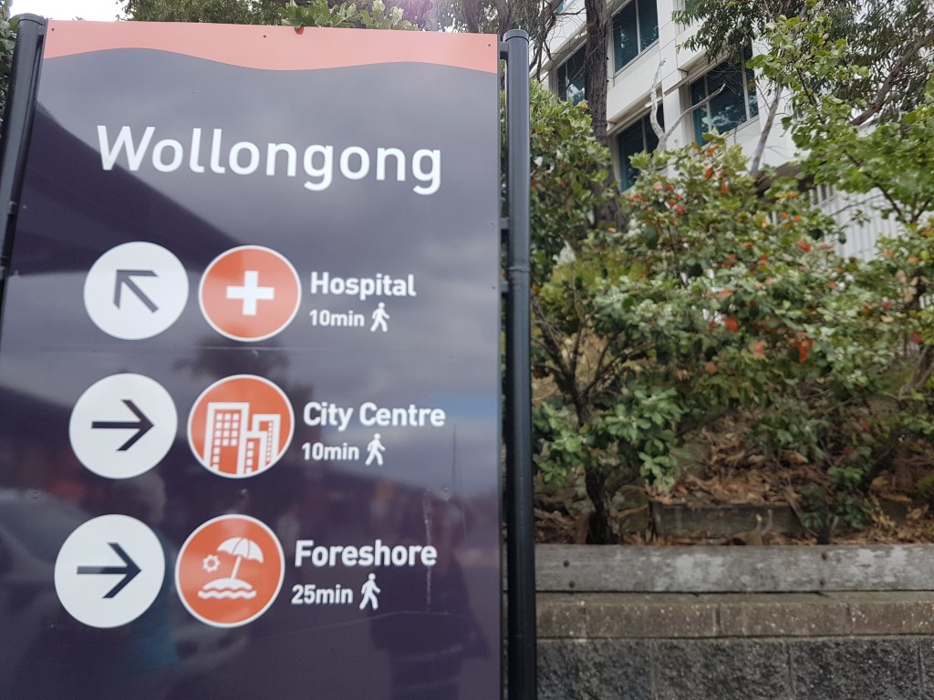 Wollongong sign shows the directions to the hospital, city centre and foreshore
