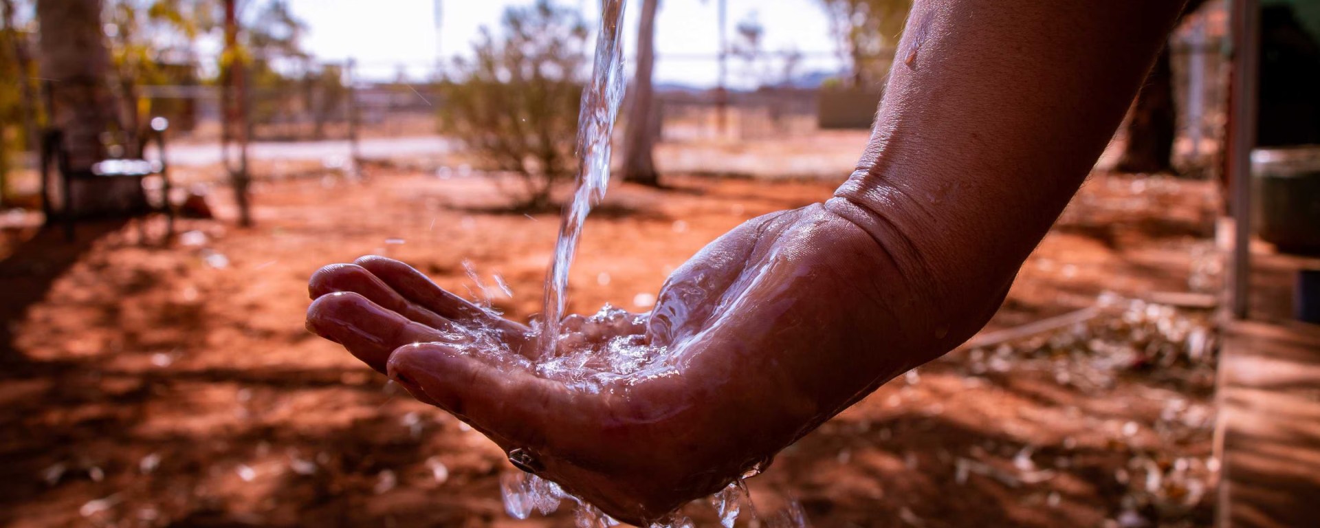 A person's hand is cupped while water pours in