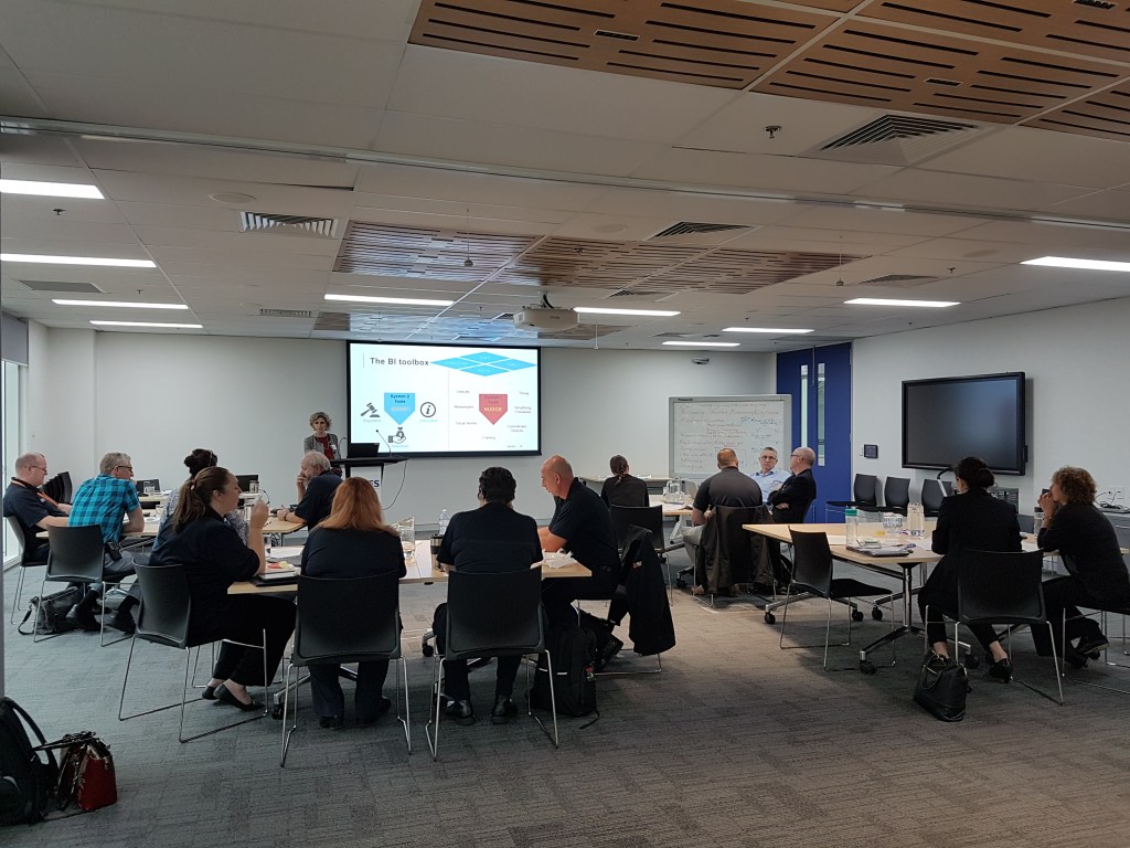 SES staff sit in groups watching our presentation
