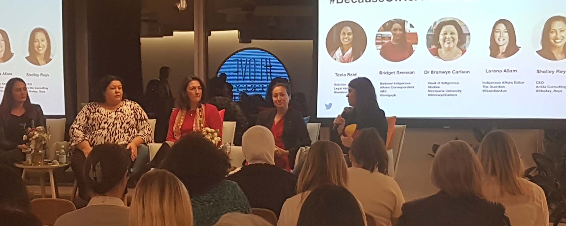 Aboriginal women speakers sit up front of an audience at Twitter Australia headquarters