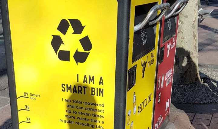 Yellow smart bin in Melbourne. Writing on the side says 'I am a smart bin'
