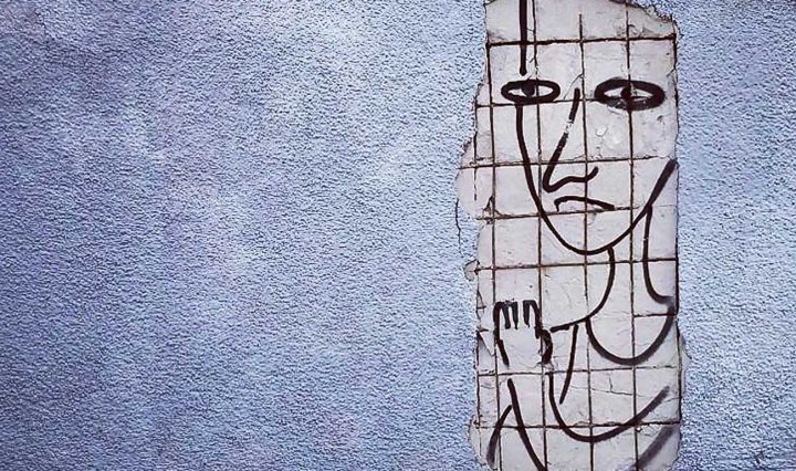 A textured wall with a poster drawing of a person behind a grid