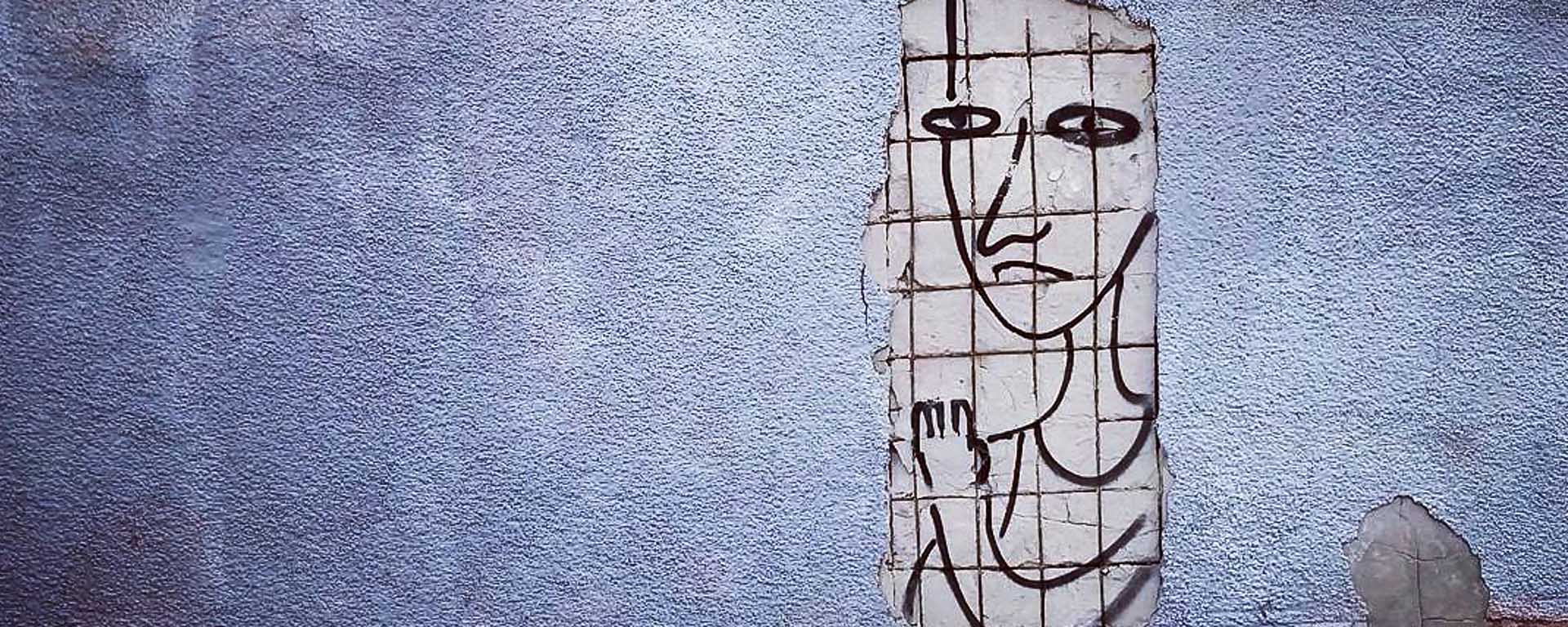 A textured wall with a poster drawing of a person behind a grid