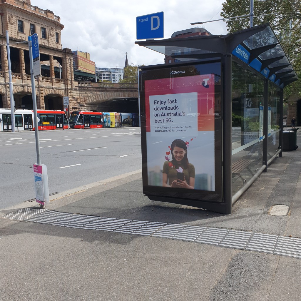 Bus stop across Central station. A sign on a post is hard to read