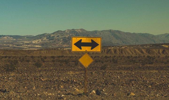 Road sign showing arrows in opposite directions