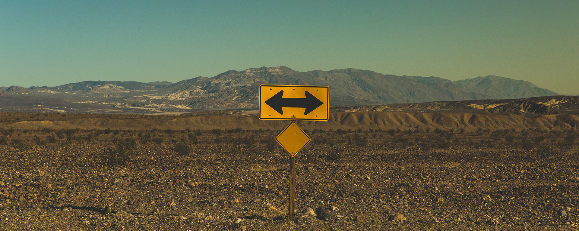 Road sign showing arrows in opposite directions