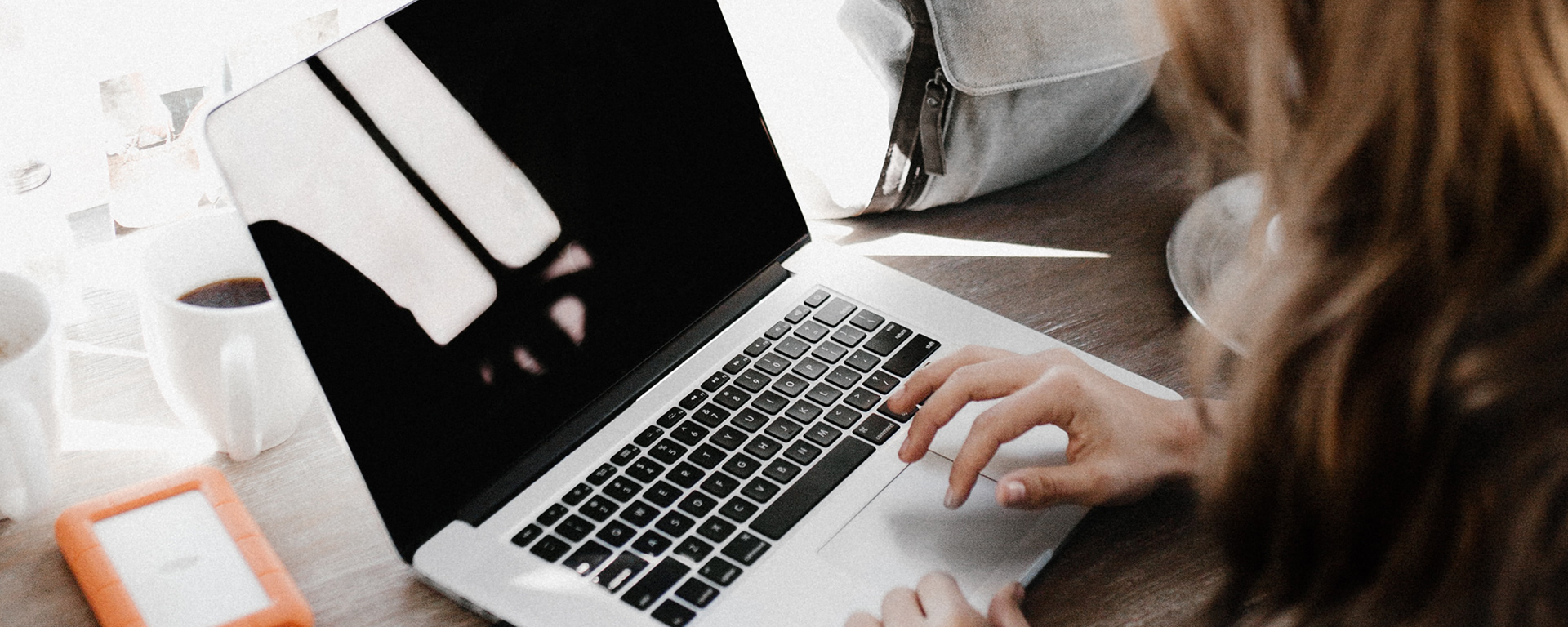 Woman's hands typing on a laptop