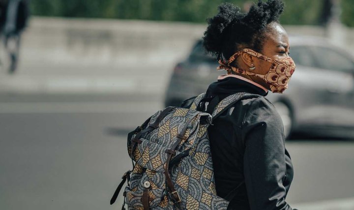 A young Black woman wears a COVID-19 face mask