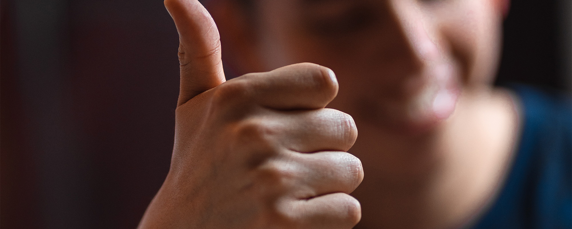 Close up on the thumbs up sign by a man of colour