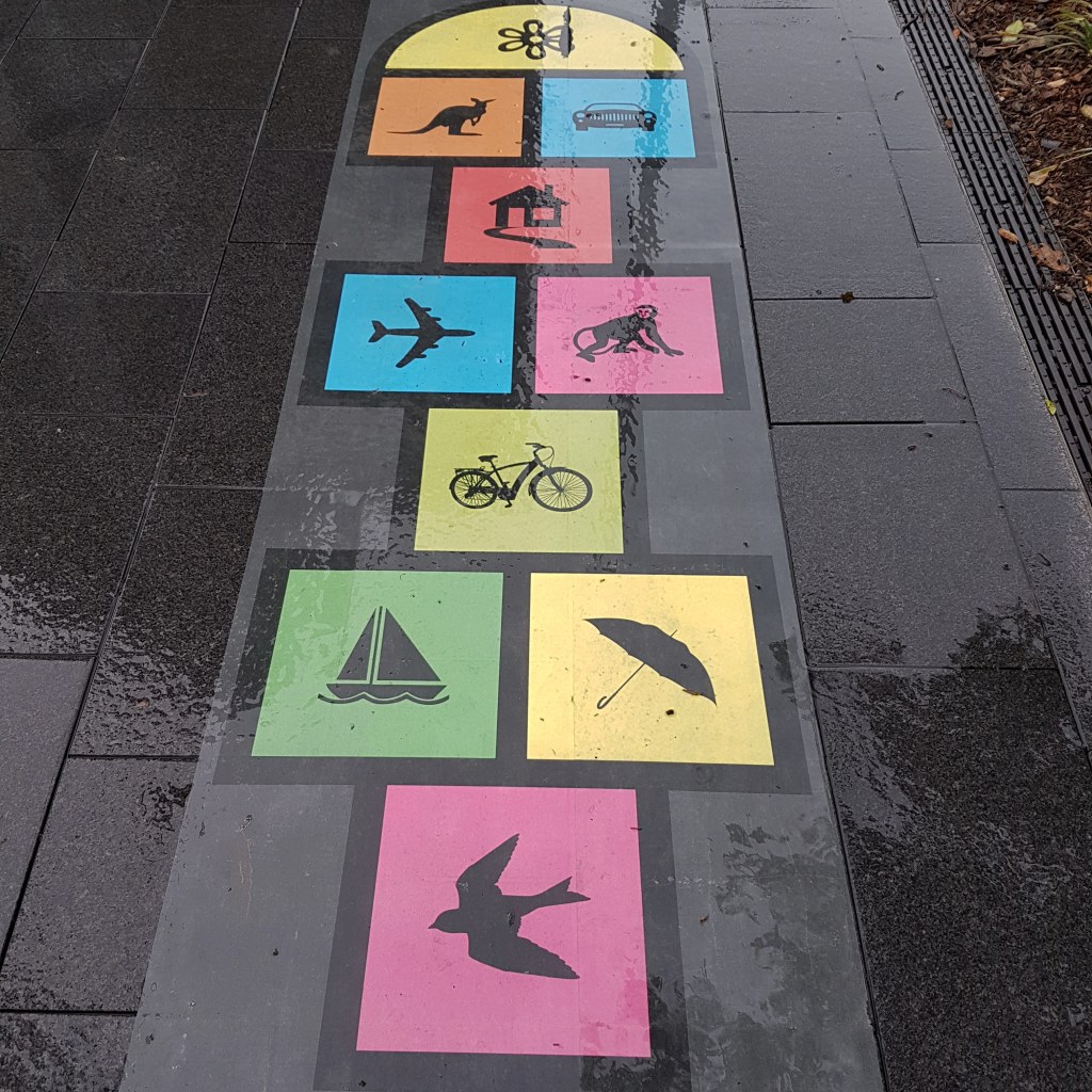 Hopscotch showing colourful drawings instead of numbers, such as a kangaroo, monkey, umbrella and a bird