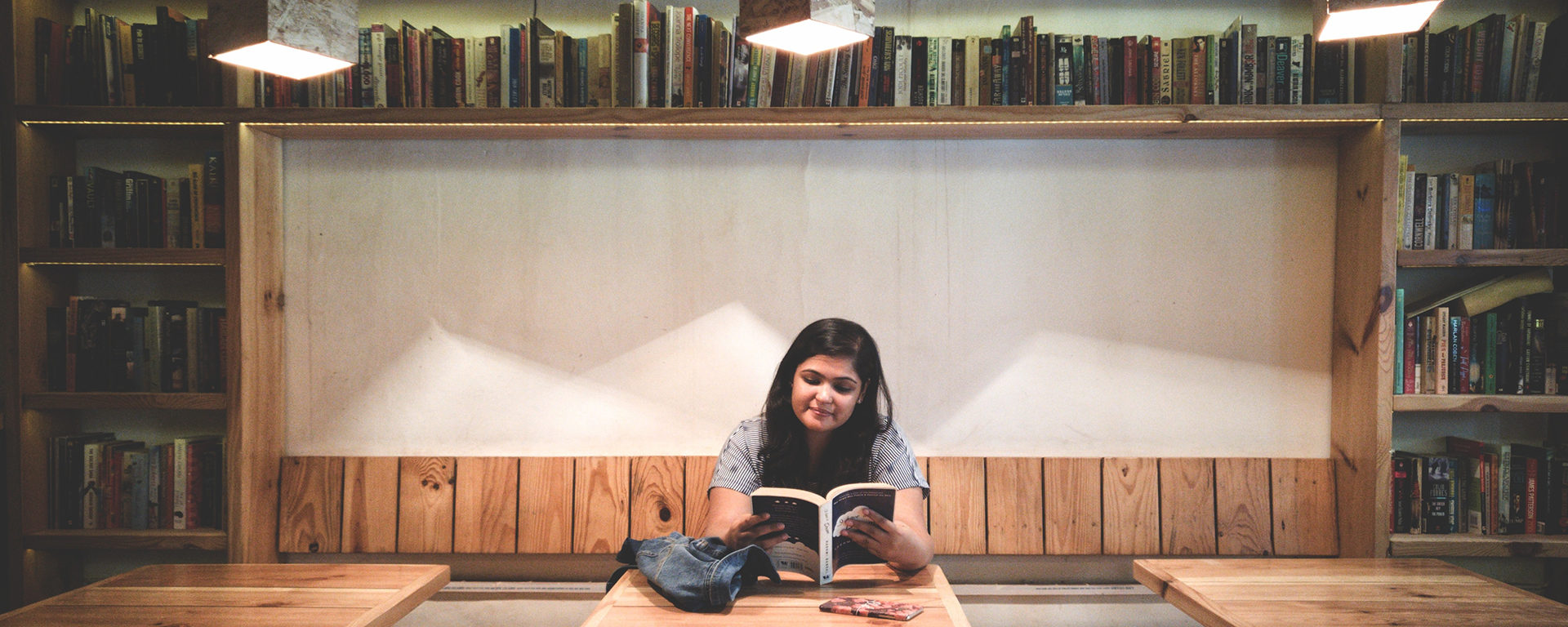 An Indian woman is reading in a library