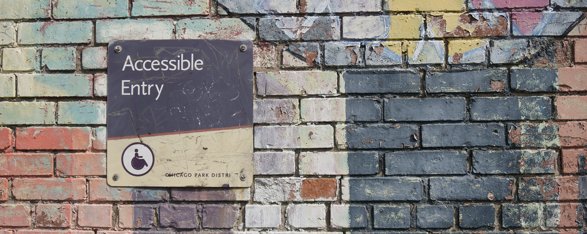 A colourful wall with a sign that says: accessible entry