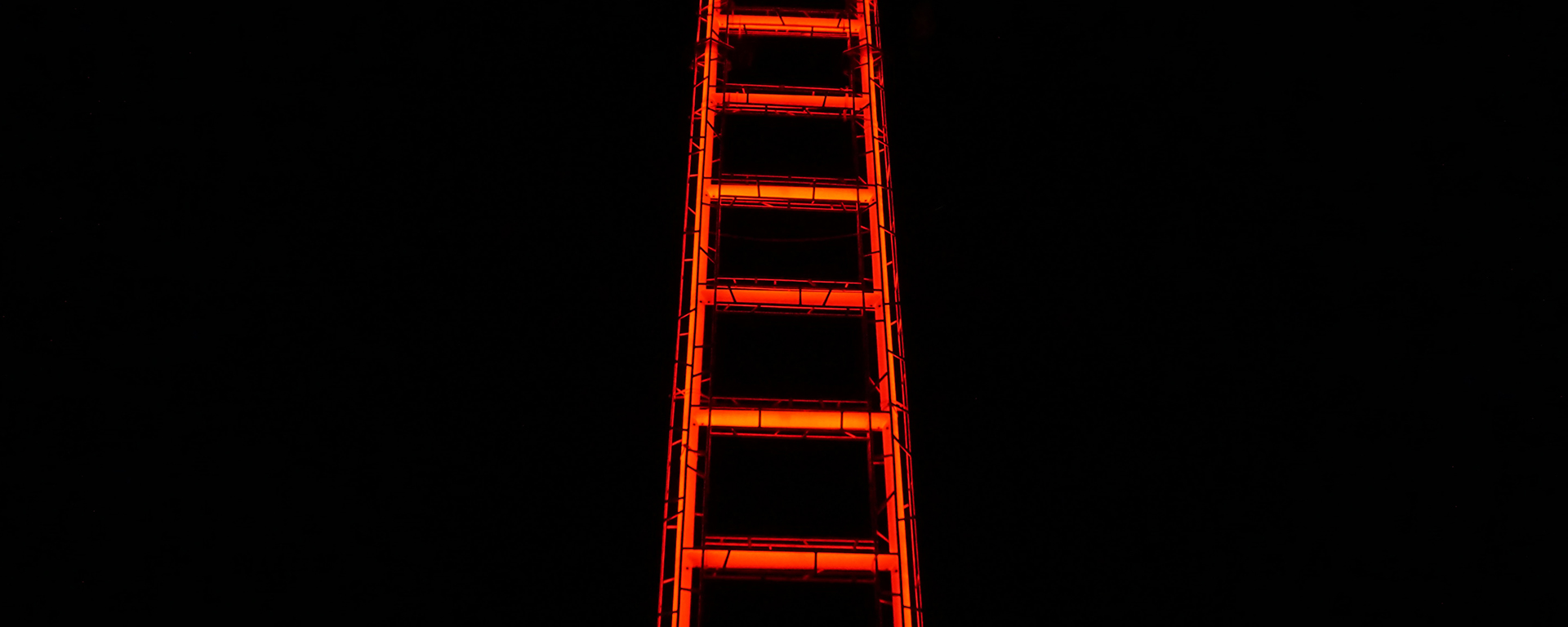 A neon ladder against a black background