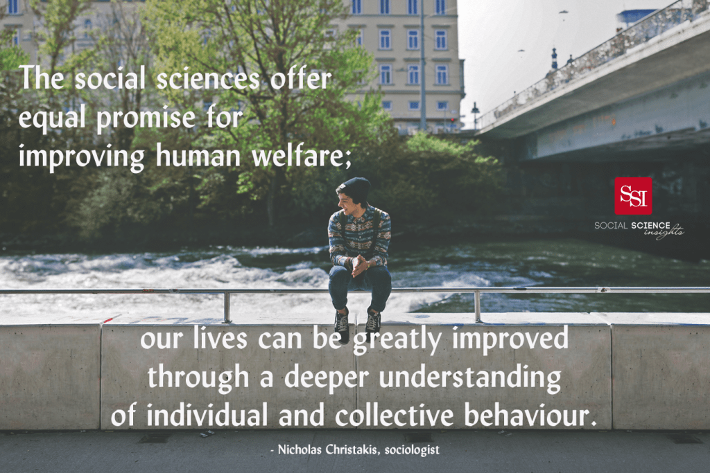 A young white man sits on a railing, with water rushing behind him. He is smiling with this palms together. Quote by Nicholas Christakis overlaid