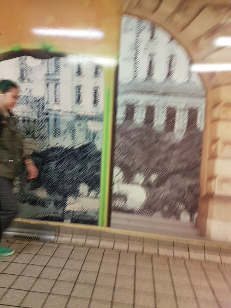 A woman walks past a mural at Central Station