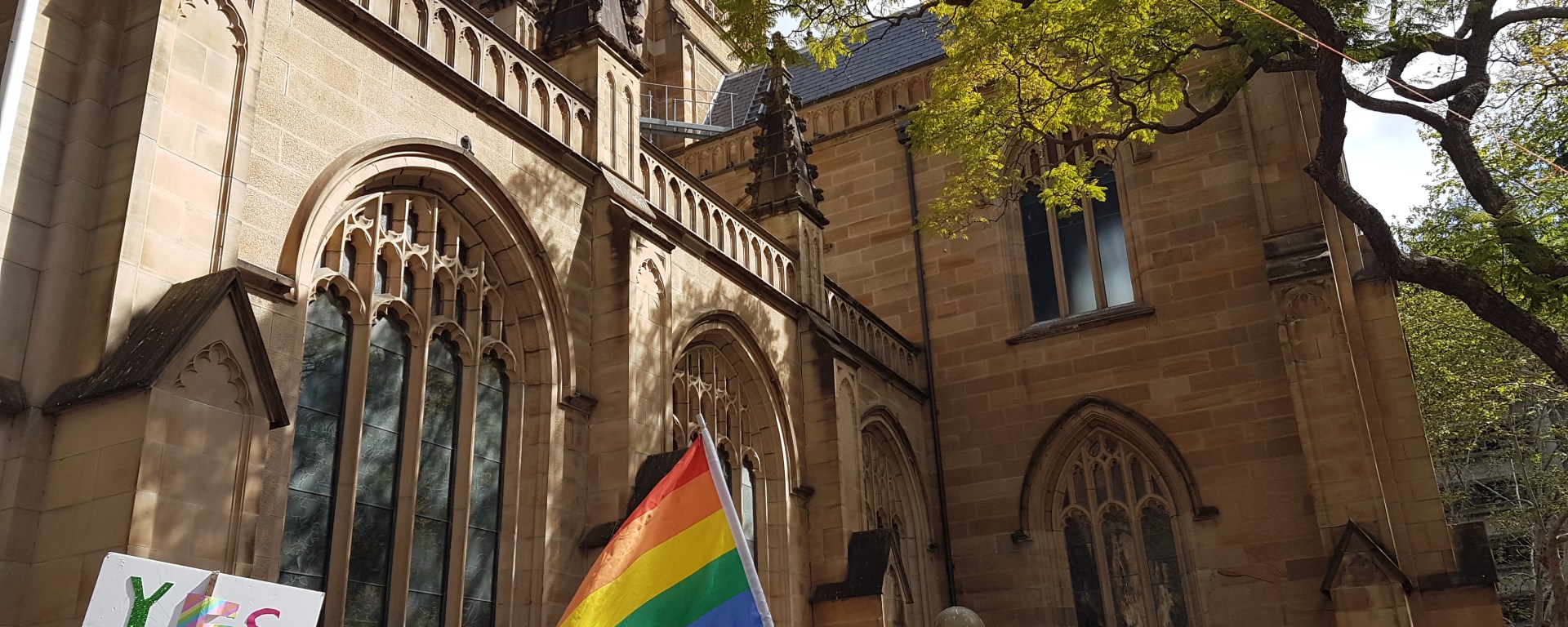 The Pride Flag and a sign saying "YES" at the Marriage Equality march in Sydney
