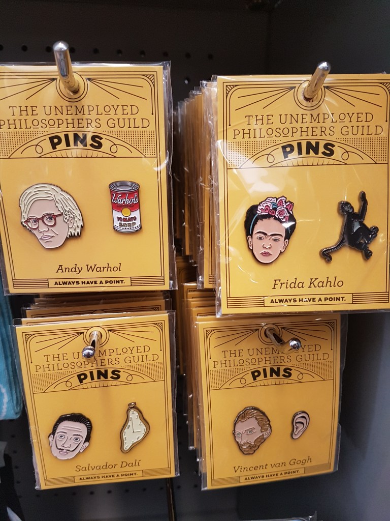 Ceramic pins showing Andy Warhol, Frida Kahlo, Salvador Dali, and Vincent van Gogh