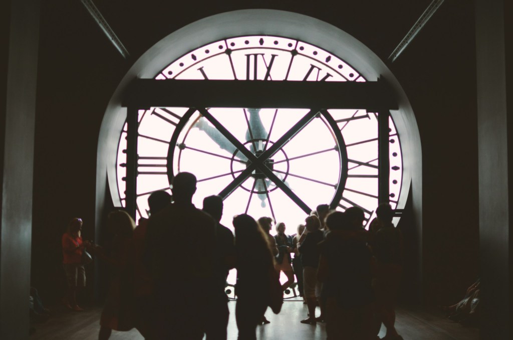People stand in front of a large clock