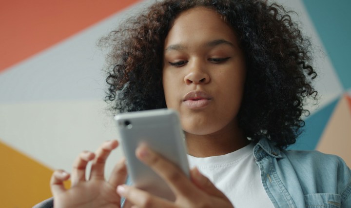 Young Black woman scrolling on her phone