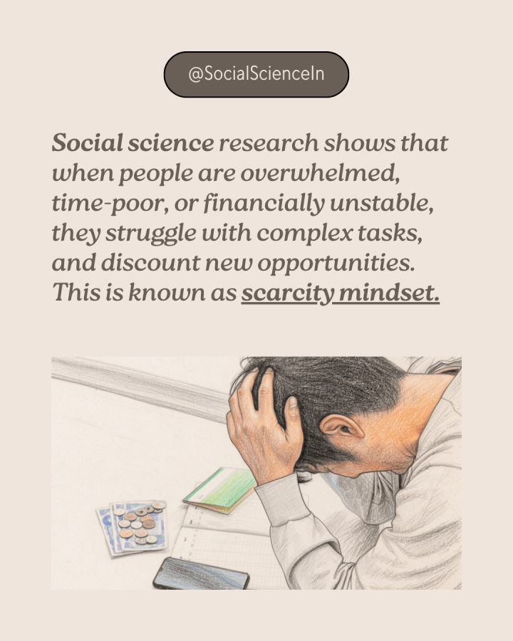 An Asian man has his head down, as he runs his fingers through his hair in exasperation. In front of him is his phone, banking book, plus a few coins and notes