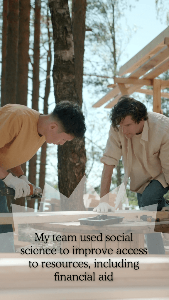 An Asian boy and a white boy are working with tools, cutting wood outdoors, with the frame of a house behind them